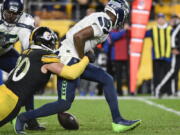 Seattle Seahawks quarterback Geno Smith (7) fumbles as Pittsburgh Steelers outside linebacker T.J. Watt (90) tackles him during overtime of an NFL football game, Sunday, Oct. 17, 2021, in Pittsburgh. The Steelers won 23-20 in overtime.