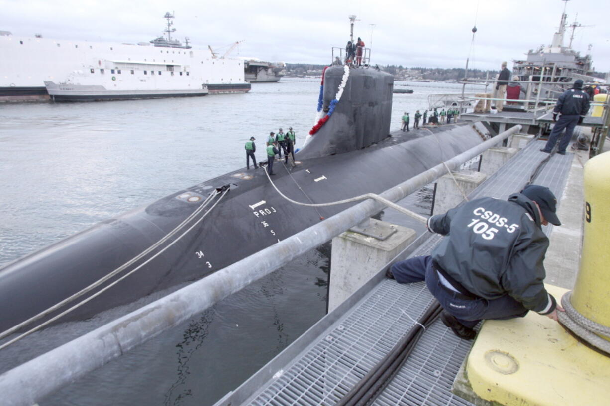 FILE - This Jan. 29, 2008 file photo shows the USS Connecticut as sailors tie up the ship at the Delta Pier at Naval Base Kitsap in Bremerton, Wash. A Navy official says the submarine that collided with an unknown underwater object in the South China Sea has arrived in port at Guam. The Navy says the USS Connecticut was conducting routine operations when it struck the object on Oct. 2.