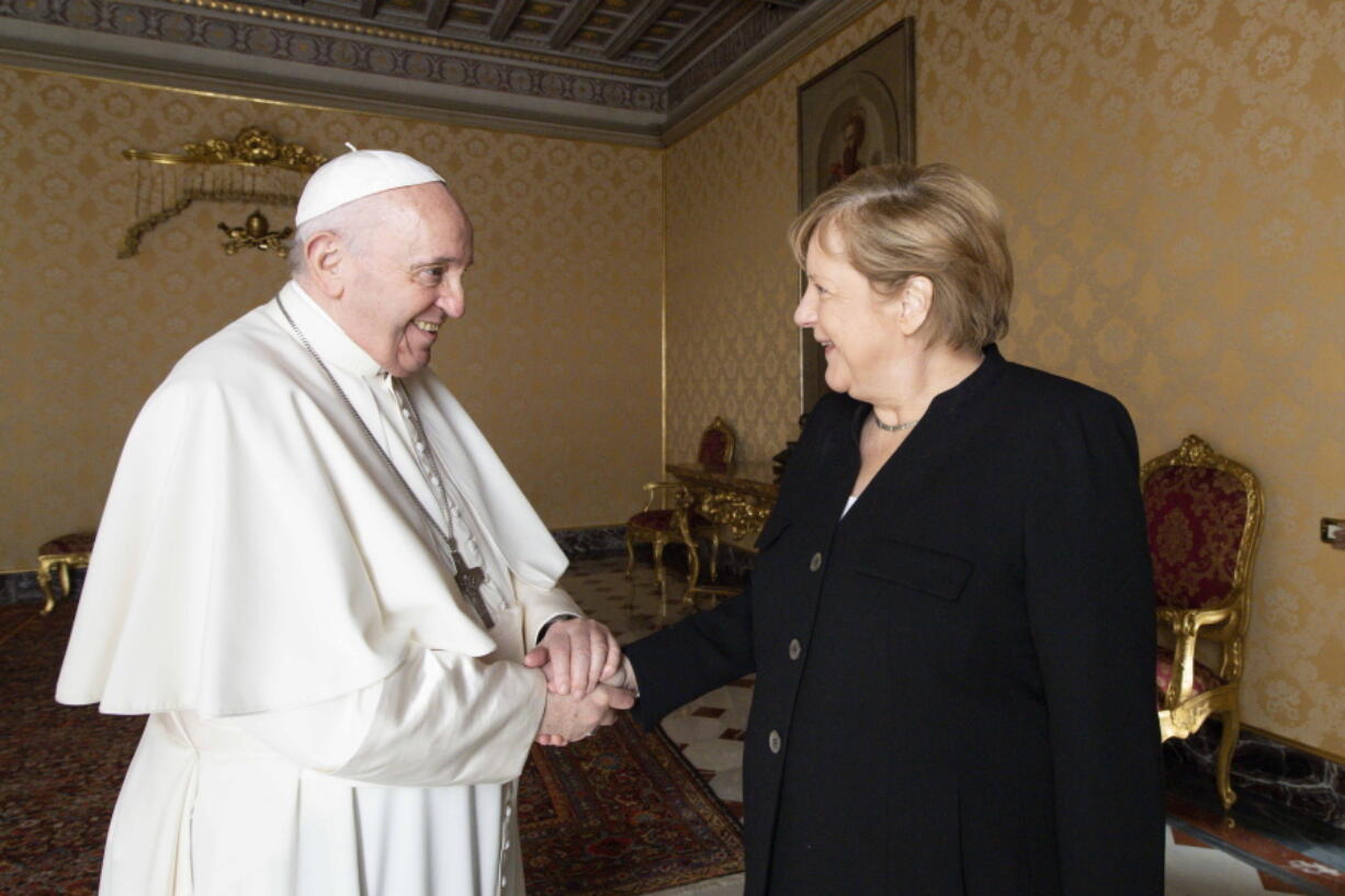 Pope Francis receives German Chancellor Angela Merkel, right, in his Library at the Vatican, Thursday, Oct. 7, 2021.