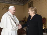 Pope Francis receives German Chancellor Angela Merkel, right, in his Library at the Vatican, Thursday, Oct. 7, 2021.