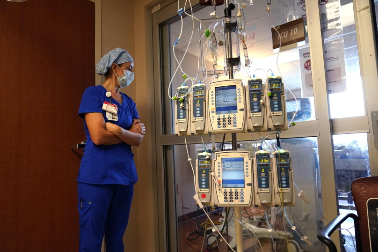 FILE - In this Aug. 17, 2021, file photo, nursing coordinator Beth Springer looks into a patient's room in a COVID-19 ward at the Willis-Knighton Medical Center in Shreveport, La. A decline in COVID-19 cases in the United States over the last several weeks has given overwhelmed hospitals some relief, but administrators are bracing for yet another possible surge as cold weather drives people indoors.