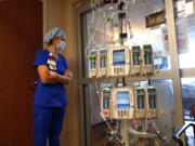 FILE - In this Aug. 17, 2021, file photo, nursing coordinator Beth Springer looks into a patient's room in a COVID-19 ward at the Willis-Knighton Medical Center in Shreveport, La. A decline in COVID-19 cases in the United States over the last several weeks has given overwhelmed hospitals some relief, but administrators are bracing for yet another possible surge as cold weather drives people indoors.