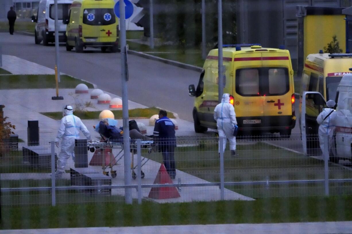 Medical workers carry a patient suspected of having coronavirus on a stretcher at a hospital in Kommunarka, outside Moscow, Russia, Saturday, Oct. 16, 2021. Russia's daily death toll from COVID-19 has exceeded 1000 for the first time as the country faces a sustained wave of rising infections.