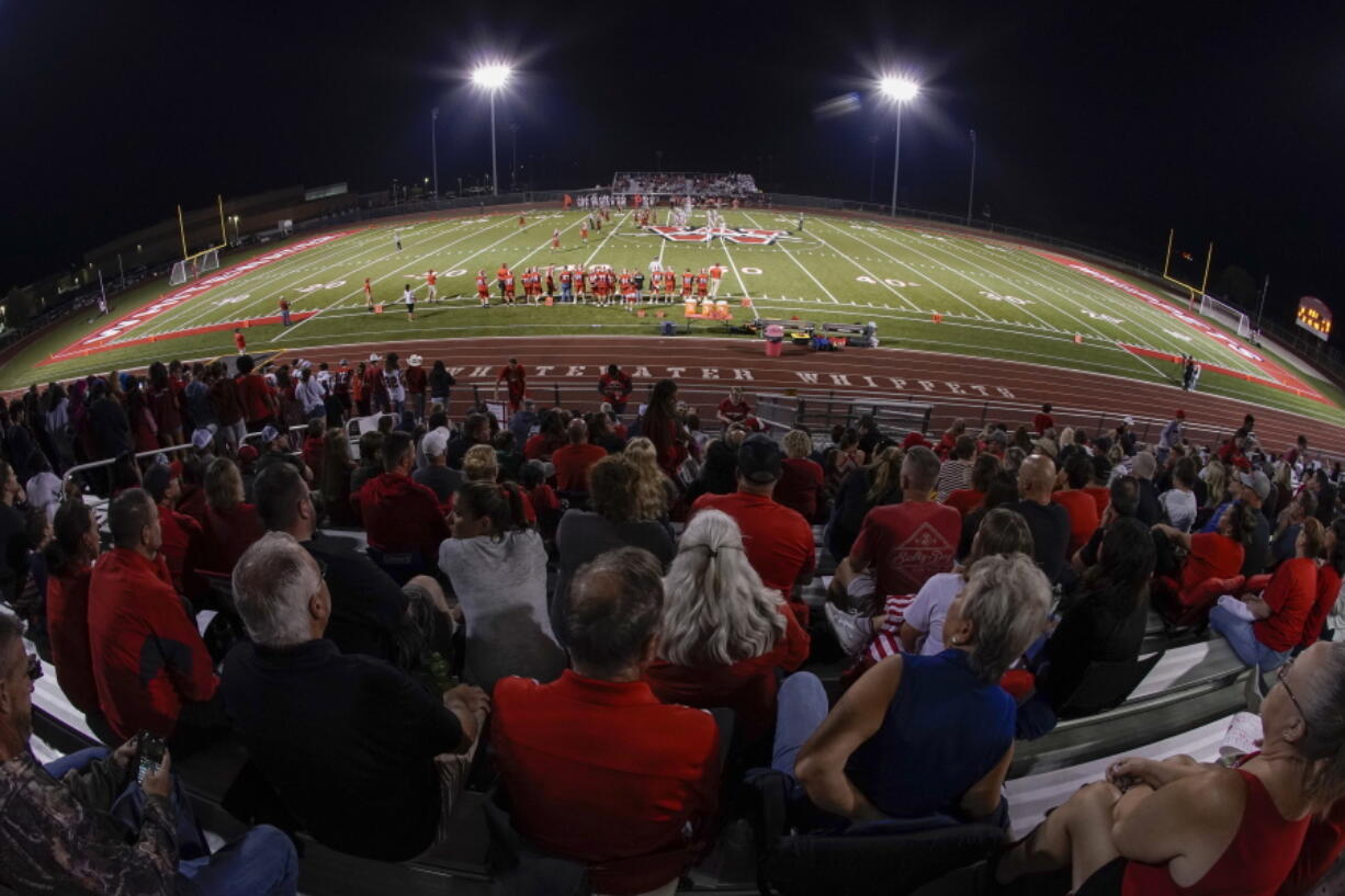 Fans fill the stadium at the football field at Whitewater High School on Friday, Oct. 1, 2021, in Whitewater, Wis. A growing number of school districts in the U.S. are using federal pandemic funding on athletics projects. When school officials at Whitewater learned they would be getting $2 million in pandemic relief this year, they decided to set most of it aside to cover costs from their current budget, freeing up $1.6 million in local funding that's being used to build new synthetic turf fields for football, baseball and softball.