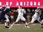 Washington quarterback Dylan Morris (9) throws a pass during the first half of the team's NCAA college football game against Arizona on Friday, Oct. 22, 2021, in Tucson, Ariz.