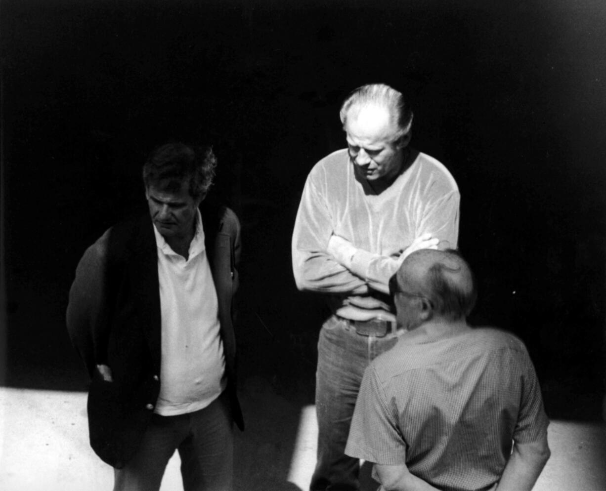 This 1980 black and white surveillance photo released by the U.S. Attorney's Office and presented as evidence during the first day of a trial for James "Whitey" Bulger in U.S. District Court in Boston, Wednesday, June 12, 2013, shows Bulger, center, with Ted Berenson, left, and Phil Wagenheim at a Lancaster Street garage in Boston's North End. Three years after he was bludgeoned to death in a West Virginia prison, no one has been charged in the beating death of murderous Boston crime boss James "Whitey" Bulger. Bulger was 89 when he was fatally beaten in October 2018. (AP Photo/U.S.