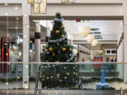 A two-story Christmas tree sits among hanging holiday lights at Vancouver Mall, which is already in Christmas mode. The mall is also at near peak capacity with tenants after eight new stores opened in eight weeks. Retailers are expecting a busier than average year, especially with no indoor capacity limits.