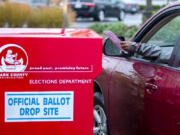 A voter drops off a ballot at a Clark County ballot drop box in the Vancouver Mall parking lot in 2020. Voter turnout is shaping up to be low in this off-year election.