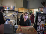 Ian Roy of Bessolo Pizzeria, left, joins colleagues Matt LeMieux, Courtney Taylor and owner Dan Wyatt as they work behind the scenes in downtown Vancouver on Monday afternoon. Wyatt, owner of Kiggins Theatre, purchased the restaurant that used to be Vinnie's Pizza and changed the name to Bessolo Pizzeria but kept the staff, menu and recipes.