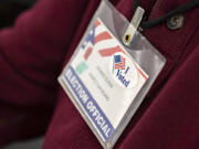 Ballot inspection board member Dennis Olson wears a sticker on his badge in honor of the current election while working at the Clark County Elections Office on Tuesday morning, Nov. 2, 2021.