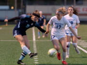 Hockinson's Ellie Ritter delivers a cross as Ridgefield's Ava Kruckenberg defends in the 2A District Girls Soccer Championship on Thursday, Nov. 4, 2021, at District Stadium in Battle Ground.