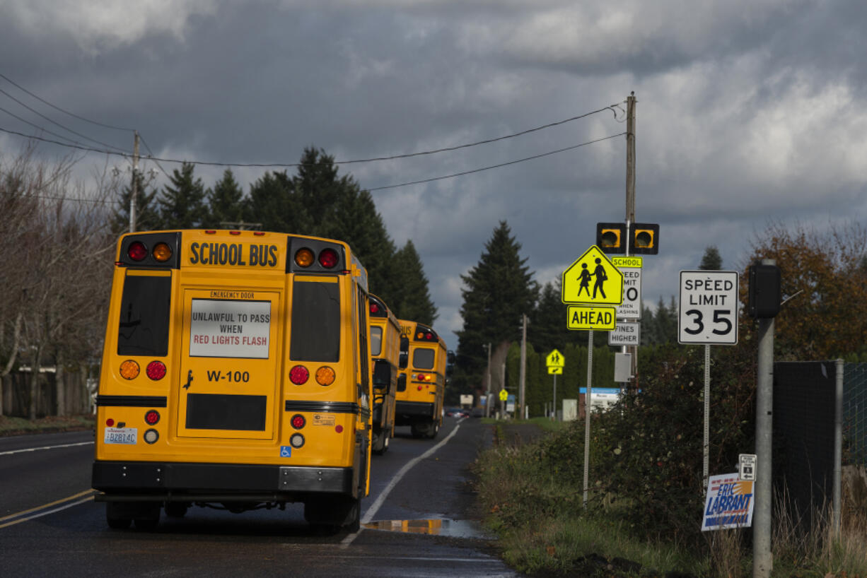 A school bus passes a speed limit sign near the intersection of Northeast 18th Street and 172nd Avenue on Friday afternoon.