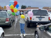 Prairie High School freshman Leena Dang attaches balloons with inspirational messages to cars in the parking lot.