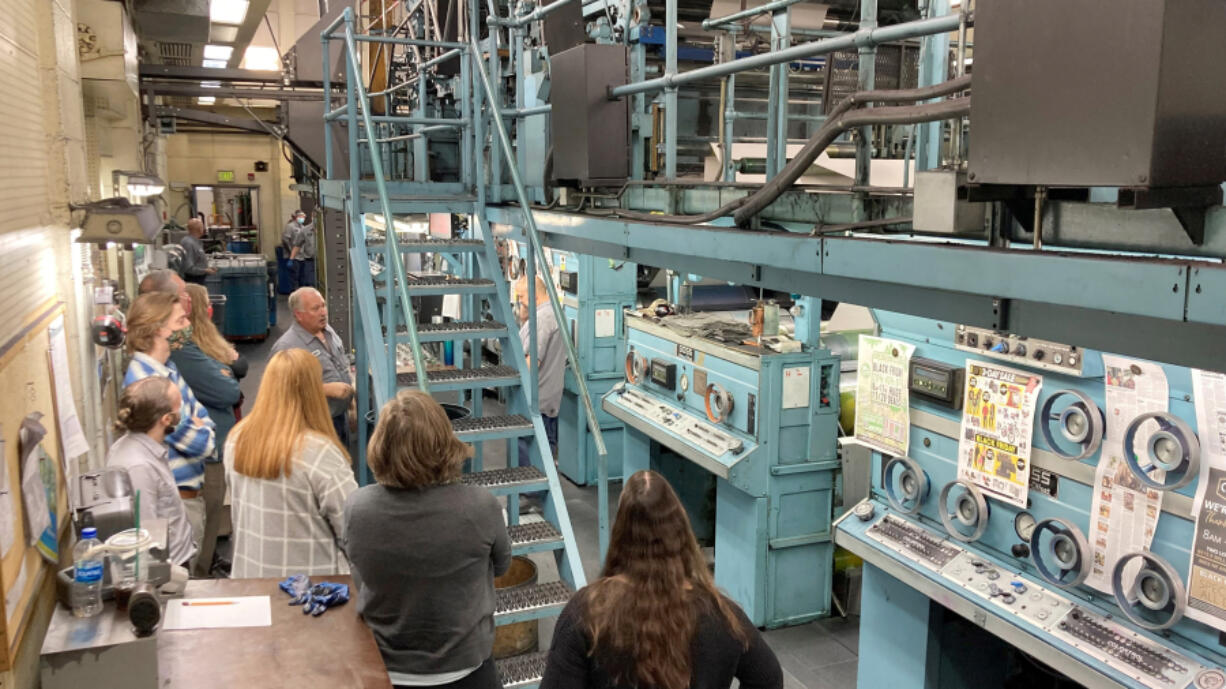 Press operator Steve Fessler talks with newsroom employees about the intricacies of working The Columbian's Goss Metro offset press on Tuesday before the paper's Thanksgiving edition went to press.