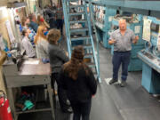 Press operator Steve Fessler talks with newsroom employees about the intricacies of working The Columbian's Goss Metro offset press on Tuesday before the paper's Thanksgiving edition went to press.