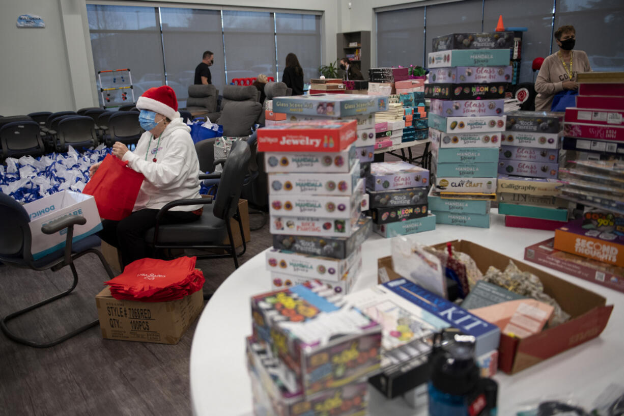 Ruth Cunningham helps assemble more than 1,000 gift bags at CDM Caregiving Services on Tuesday afternoon. The bags will be distributed to Clark County caregivers at the second annual Caregiver Christmas on Dec. 7.