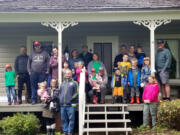 EVERGREEN HIGHWAY: Tiger Den Cub Scouts from Pack 310, under the leadership of Margarita Skeels, earned badges planting mums and pansies at the Jane Weber Evergreen Arboretum. Here are the scouts and their families on the porch of the historic Stanger House on the grounds of the arboretum.