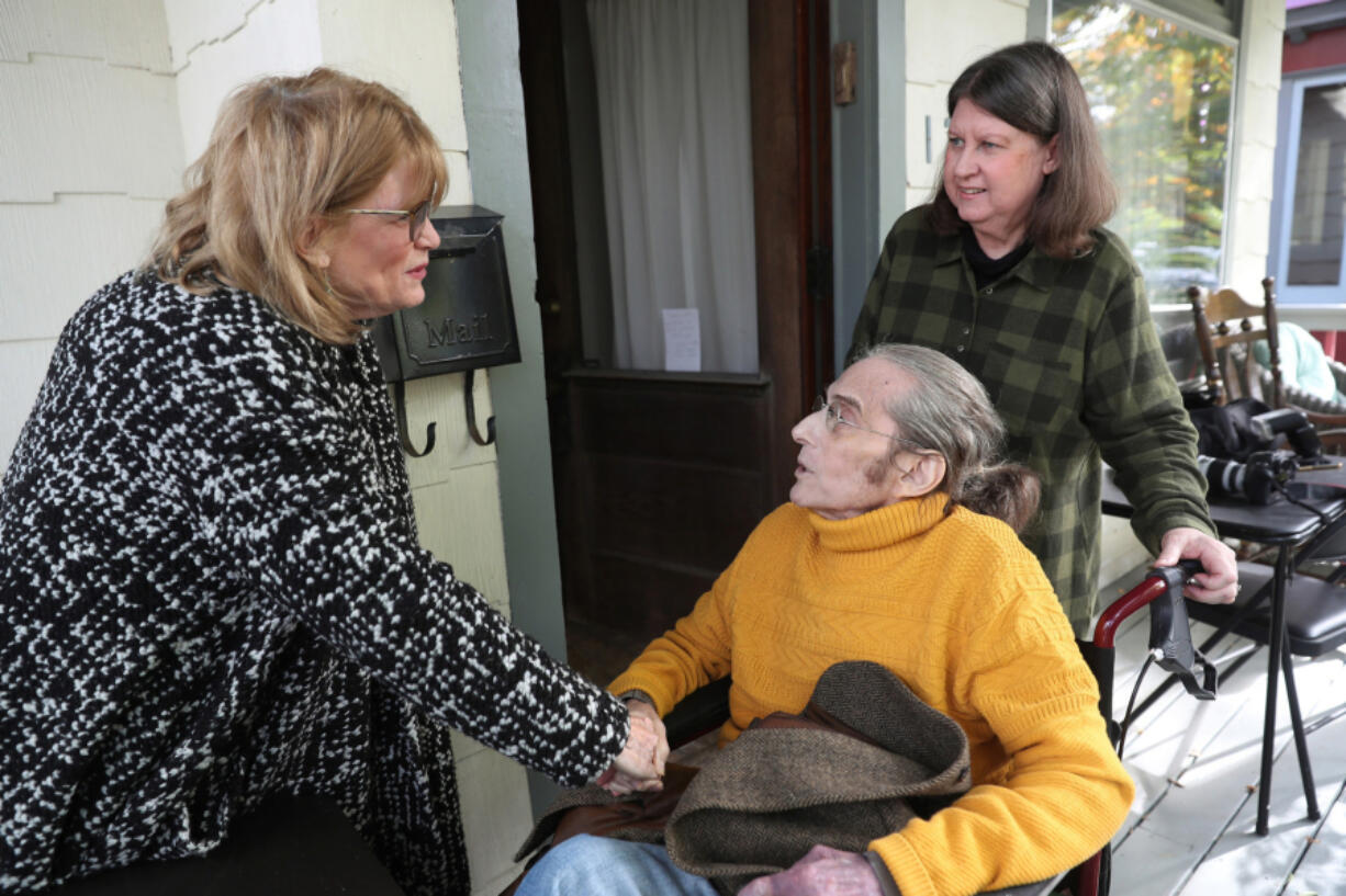 Rabbi Douglas Goldhamer is greeted by colleague and former student Alison Brown, left, as his wife Peggy Bagley assists the rabbi at home Oct. 26 in Evanston, Ill. (John J.