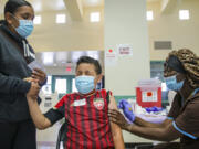 Christiana Neri holds her 13-year-old son, Ivan Hernandez, as Sequoia Hutton administers the Pfizer COVID-19 vaccine at a mobile vaccine clinic held for people age 12 and over at Roosevelt Park on  May 14, 2021, in Los Angeles.