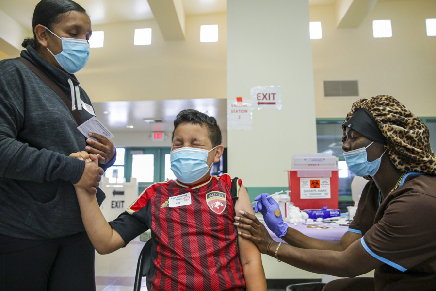 Christiana Neri holds her 13-year-old son, Ivan Hernandez, as Sequoia Hutton administers the Pfizer COVID-19 vaccine at a mobile vaccine clinic held for people age 12 and over at Roosevelt Park on  May 14, 2021, in Los Angeles.