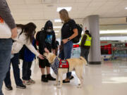 The Shoup family stops on the way to their flight to pet Yakeley, a dog from Paw Force One, at John Glenn Columbus International Airport in Columbus, Ohio.