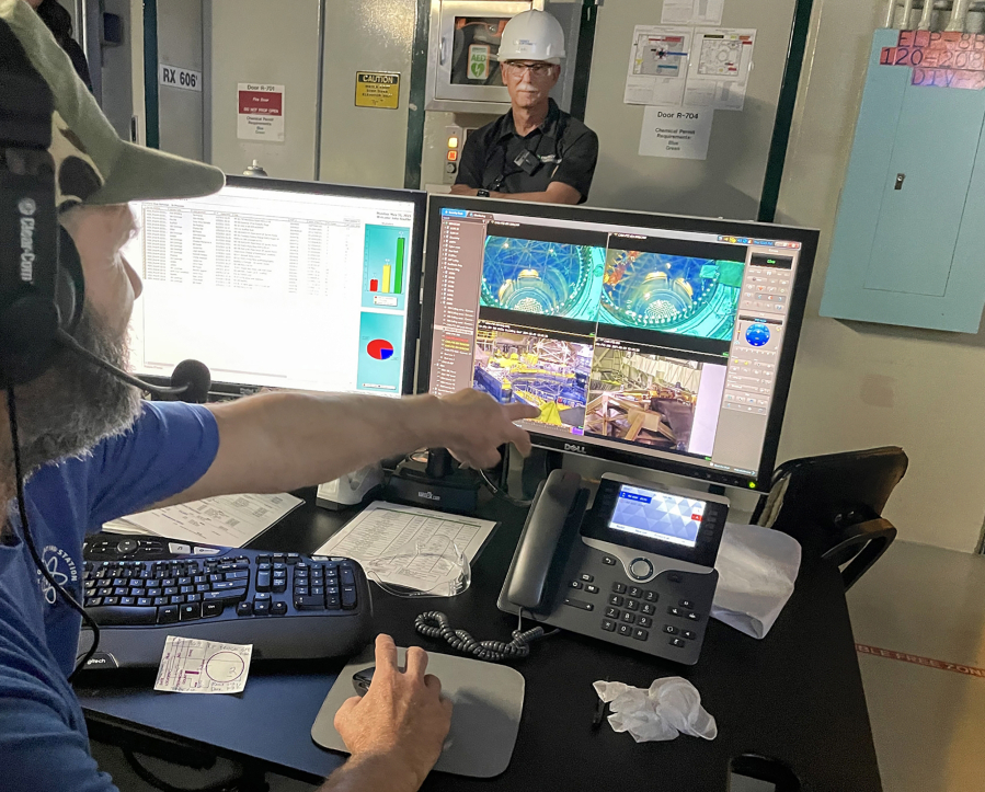 At his post at the Columbia Generating Station, John Boothe monitors the spring refueling on his computer, which relayed images from the submerged reactor core in Benton County, Washington. Bob Schuetz, CEO of Energy Northwest, is in the white hard hat.