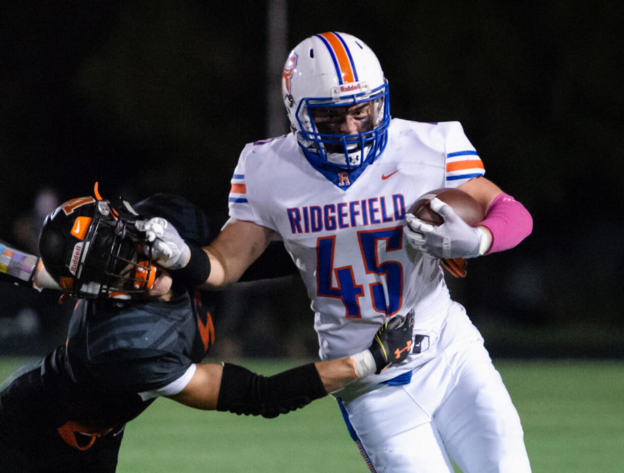 Ridgefield's Connor Delamarter stiff arms a Washougal defender in a 2A Greater St. Helens League football game on Friday, Oct. 1, 2021, at Fishback Stadium in Washougal.