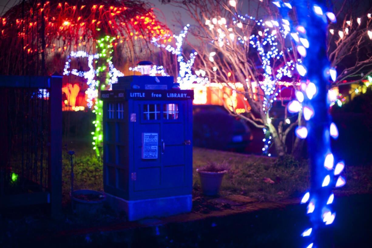 A Lincoln neighborhood house is illuminated with holiday lights while the TARDIS library stands sentinel in 2019.