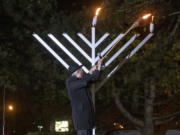 Rabbi Shmulik Greenberg lights the Menorah to celebrate the first day of Hanukkah at a Drive-In Grand Menorah Lighting in a parking lot across the street from the Clark County Historical Museum on Thursday night, Dec. 10, 2020.