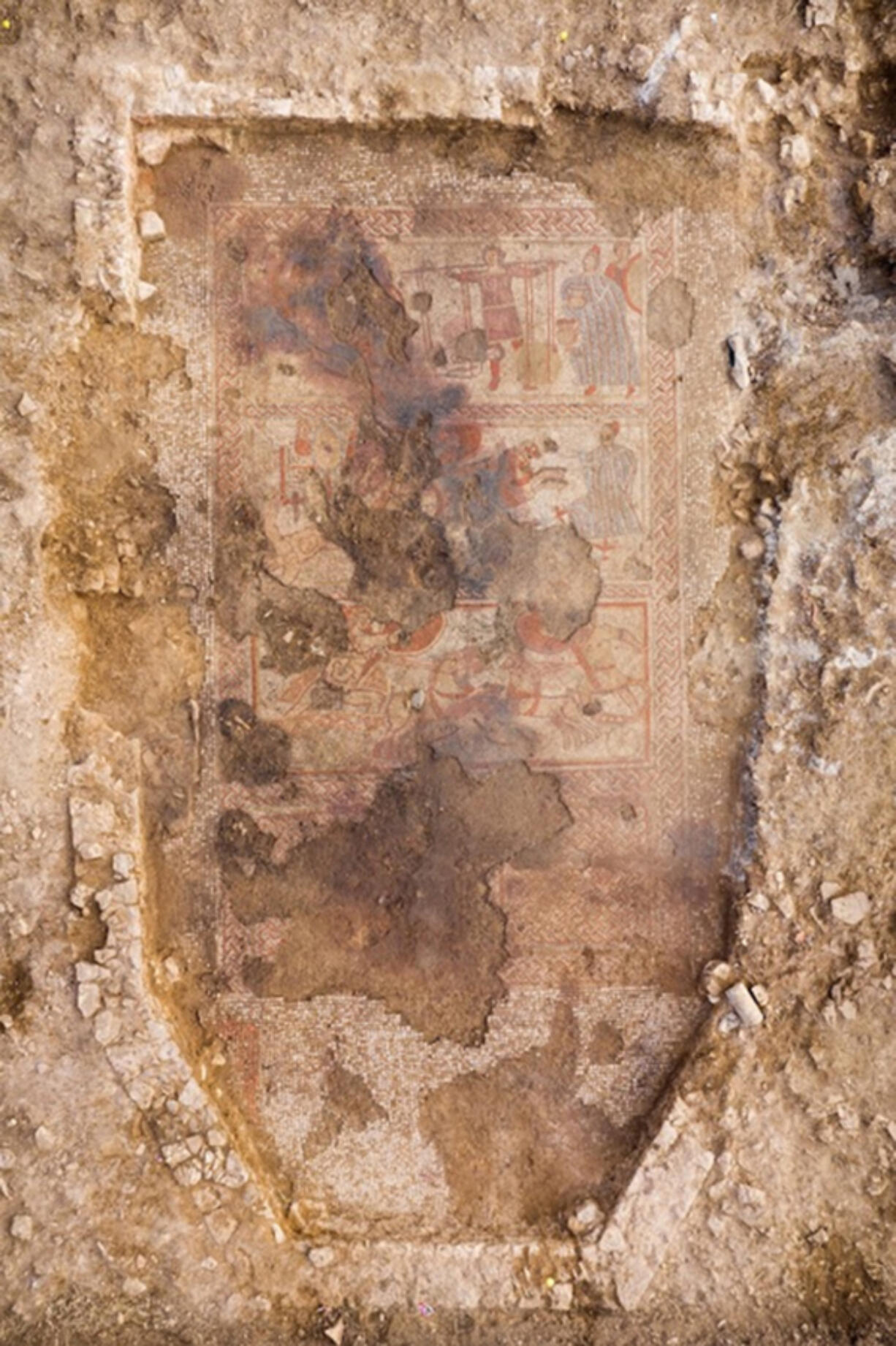 Image of the full mosaic in situ, displaying three panels, with damage, featuring Achilles. According to a team from the University of Leicester Archaeological Services, the mosaic was discovered last year by the son of a landowner in the English county of Rutland.