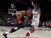 Portland Trail Blazers guard CJ McCollum, left, drives to the basket on Philadelphia 76ers guard Matisse Thybulle, right, during the second half of an NBA basketball game in Portland, Ore., Saturday, Nov. 20, 2021. The Trail Blazers won 118-111.