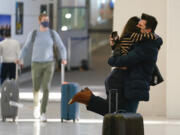 Natalia Abrahao is lifted up by her fiancé Mark Ogertsehnig as they greet one another at Newark Liberty International Airport in Newark, N.J., Monday, Nov. 8, 2021. Pandemic travel restrictions have made their recent meetings difficult and infrequent. The U.S. lifted restrictions Monday on travel from a long list of countries including Mexico, Canada and most of Europe, setting the stage for emotional reunions nearly two years in the making and providing a boost for the airline and tourism industries decimated by the pandemic.