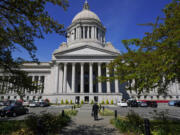 A person walks near the Legislative Building, Wednesday, April 21, 2021, at the Capitol in Olympia.  (AP Photo/Ted S.