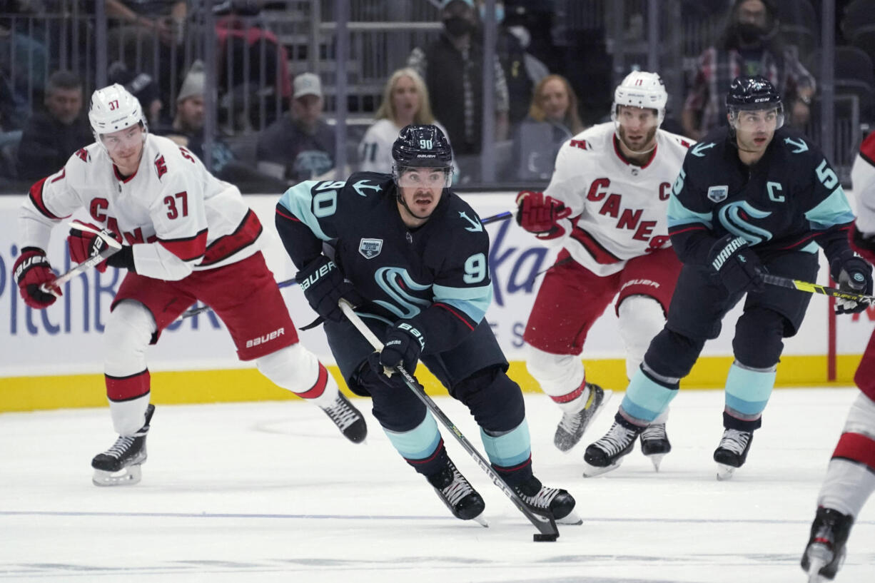 Seattle Kraken center Marcus Johansson (90) moves the puck near Carolina Hurricanes right wing Andrei Svechnikov (37) during the first period of an NHL hockey game Wednesday, Nov. 24, 2021, in Seattle. (AP Photo/Ted S.