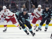 Seattle Kraken center Marcus Johansson (90) moves the puck near Carolina Hurricanes right wing Andrei Svechnikov (37) during the first period of an NHL hockey game Wednesday, Nov. 24, 2021, in Seattle. (AP Photo/Ted S.