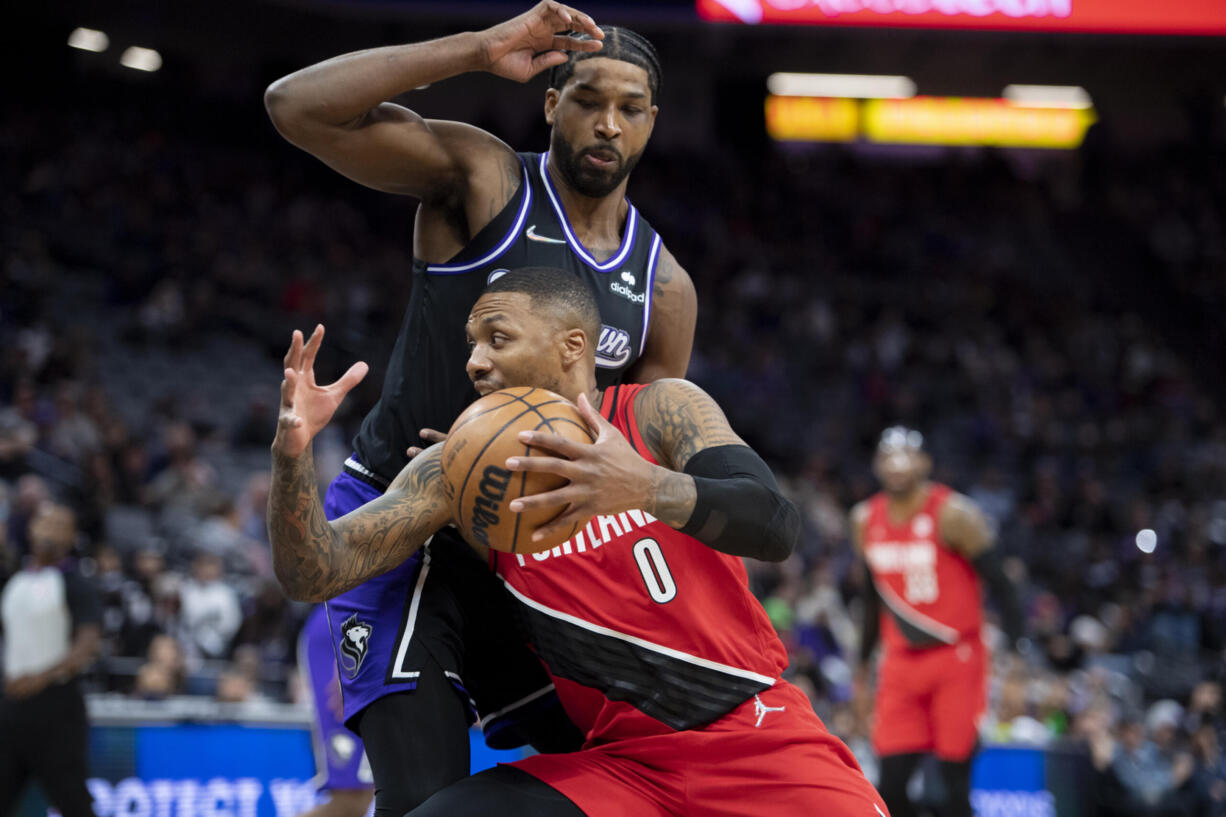 Portland Trail Blazers guard Damian Lillard (0) drives past Sacramento Kings center Tristan Thompson (13) during the first quarter of an NBA basketball game in Sacramento, Calif., Wednesday, Nov. 24, 2021.