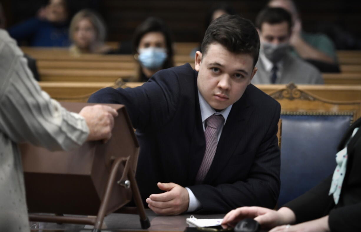 Kyle Rittenhouse pulls numbers of jurors out of a tumbler during his trail at the Kenosha County Courthouse in Kenosha, Wis., on Tuesday, Nov. 16, 2021. The jurors selected through this process will not participate in deliberations.