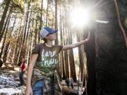 Ashtyn Perry, 13, touches the Three Sisters sequoia tree Oct. 27 during an Archangel Ancient Tree Archive planting expedition in Sequoia Crest, Calif. The seedling that was half Perry's age and barely reached her knees was part of a novel project to plant offspring from one of the largest and oldest trees on the planet to see if the genes that allowed the parent to survive so long would protect new trees from the perils of a warming planet.