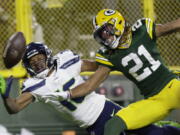 Green Bay Packers' Eric Stokes breaks up a pass intended for Seattle Seahawks' Tyler Lockett during the first half of an NFL football game Sunday, Nov. 14, 2021, in Green Bay, Wis.