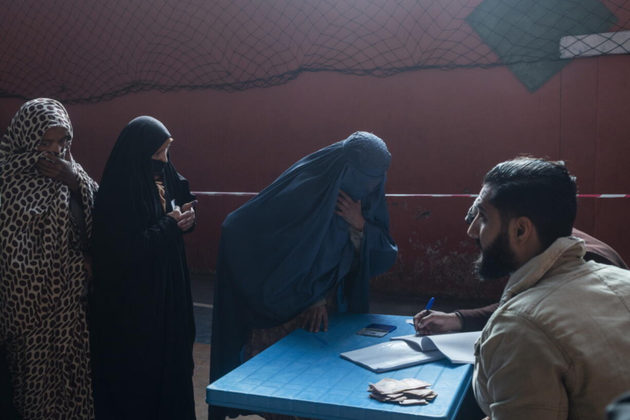 An Afghan woman resisters her name to receive cash at a money distribution center, organized by the World Food Program in Kabul, Afghanistan on Wednesday, Nov. 17, 2021. With the U.N. warning millions are in near-famine conditions, the WFP has dramatically ramped up direct aid to families.