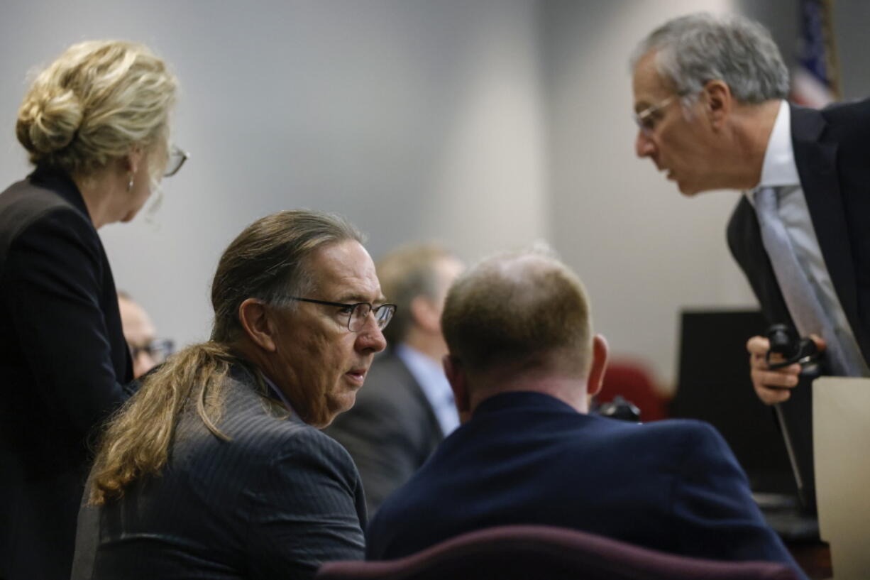 Defense attorney Franklin Hogue, center left, interacts with Travis McMichael at the jury selection in the trial of McMichael, William "Roddie" Bryan, and Gregory McMichael, charged with the February 2020 death of 25-year-old Ahmaud Arbery, at the Gwynn County Superior Court, in Brunswick, Ga., Wednesday, Oct. 27, 2021.