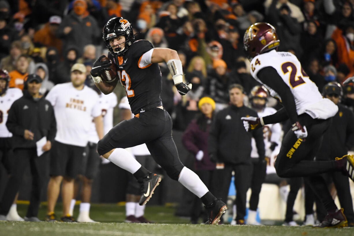 Oregon State linebacker Jack Colletto (12) is chased by Arizona State defensive back Chase Lucas (24) as he heads to the end zone after taking an offensive snap on fourth down in the fourth quarter of an NCAA college football game Saturday, Nov. 20, 2021, in Corvallis, Ore.