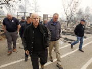 FILE - Former California Gov. Jerry Brown, center, and former Interior Secretary Ryan Zinke, second from right, tour the Camp-fire ravaged Paradise Elementary School in Paradise, Calif., on Nov. 14, 2018. Brown has called California's mega fires "the new abnormal" as climate change turns the state warmer and drier. With the help of Ken Pimlott, the former chief of the California Department of Forestry and Fire Protection, Brown convened a group at his rural Colusa County ranch in September 2021, to discuss what could be done to save California's forests.