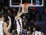 Gonzaga center Chet Holmgren, center, dunks during the first half of an NCAA college basketball game against Dixie State, Tuesday, Nov. 9, 2021, in Spokane, Wash.