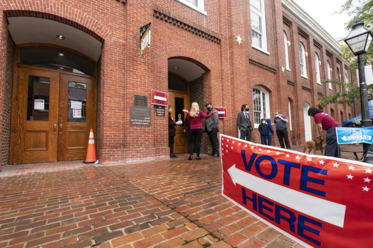 FILE - Voters arrive to cast the their ballots on Election Day at City Hall, Tuesday, Nov. 2, 2021, in Alexandria, Va. The first major election day following a year of relentless attacks on voting rights and election officials went off largely without a hitch. The relative calm was a relief to those who oversee state and local elections, but election experts say that might not matter to the millions of Americans who now believe in conspiracy theories trumpeting rampant electoral fraud.