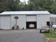 In this photo provided by the U.S. Attorney's Office is the exterior of a workshop owned by Bradley Woolard, 42, who ran a significant fentanyl pill-pressing operation from the property in Arlington, Wash., on Aug. 16, 2018. Authorities said Woolard and his right-hand man, Anthony Pelayo, 35, of Marysville, Wash., had ordered enough supplies to make 2.5 million make around 2.5 million fentanyl-laced pills before they got caught in 2018. Woolard was sentenced to 20 years in prison on Tuesday, Nov. 30, 2021. Pelayo was sentenced to 15 years on Nov. 23, 2021. (Martin Weinbaum/Snohomish County Sheriff's/U.S.