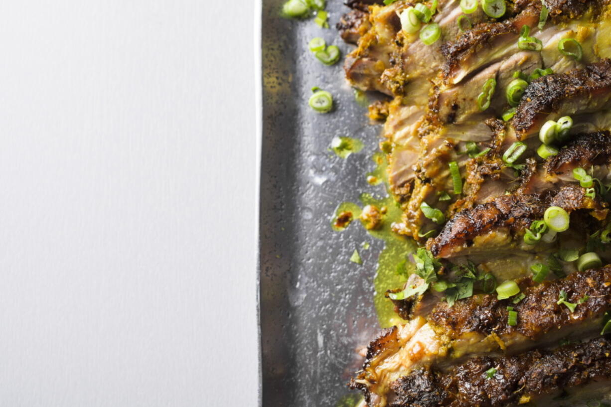 This image released by Milk Street shows a recipe for Asian roasted pork shoulder with turmeric and lemon grass.