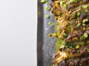 This image released by Milk Street shows a recipe for Asian roasted pork shoulder with turmeric and lemon grass.