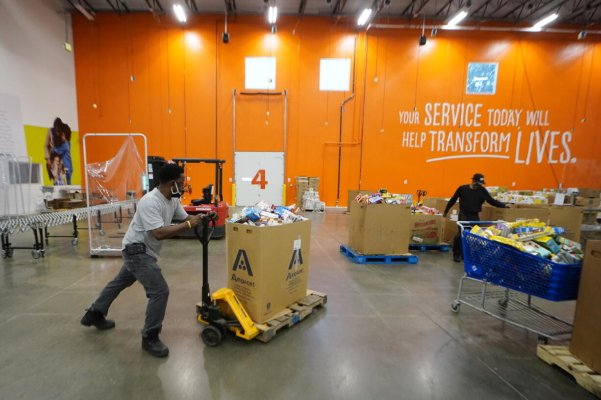 Volunteer group leader Bruce Beecham works to sort food items in the Atlanta Food Bank's Hunger Action Center Wednesday, Sept. 22, 2021, in College Park, Ga.  : Food banks have ramped up their output during the coronavirus pandemic to meet an explosion of need from families facing financial hardship. Now, some are preparing to permanently boost their food distribution with major expansion projects driven in part by their experiences during the pandemic.