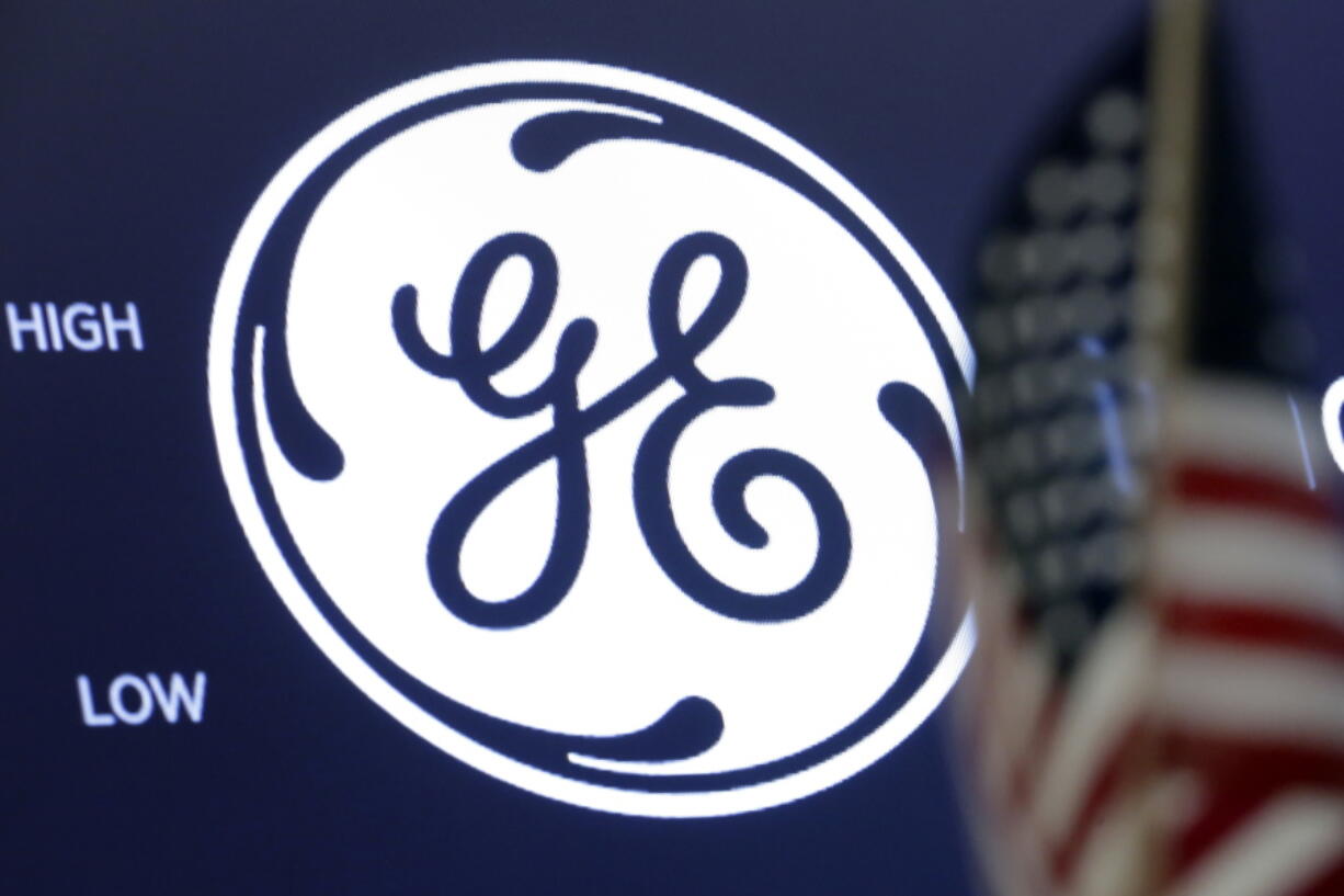 FILE - The General Electric logo appears above a trading post on the floor of the New York Stock Exchange, June 26, 2018. General Electric is splitting itself into three public companies that concentrate on aviation, healthcare and energy. The company said Tuesday, Nov. 9, 2021, that it plans a spinoff of its healthcare business in early 2023 and of its energy segment in early 2024.